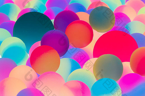 以光谱颜色为背景的照明双色球，具有多个不同尺寸球的特写视图