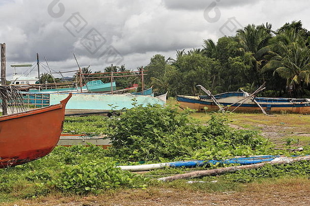 废弃的巴兰盖或邦加渔船捕鱼和旅游服务出现故障，搁浅在覆盖着尼帕棕榈叶的Polacion barangay海滩上。西帕拉