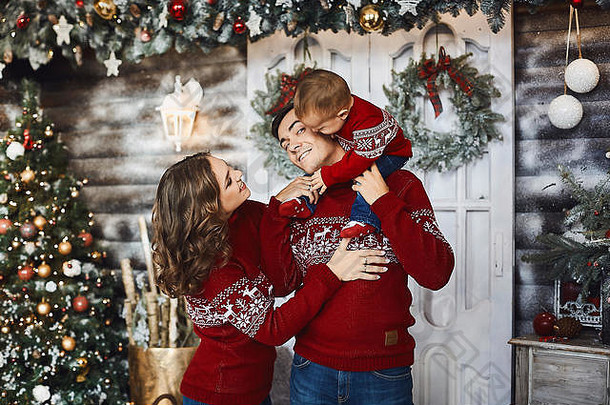 美丽的夫妇可爱的儿子时尚冬天衣服妈妈爸爸儿子拥抱有趣的圣诞节
