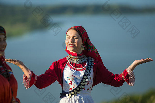 身着传统俄罗斯服装、面带微笑的年轻女子在球场上跳舞
