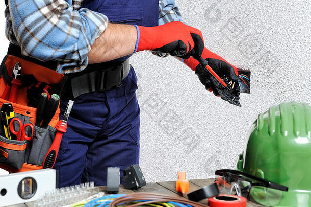 手戴手套和绝<strong>缘</strong>工具的电工在住宅电气装置中遵守安全规<strong>定</strong>。