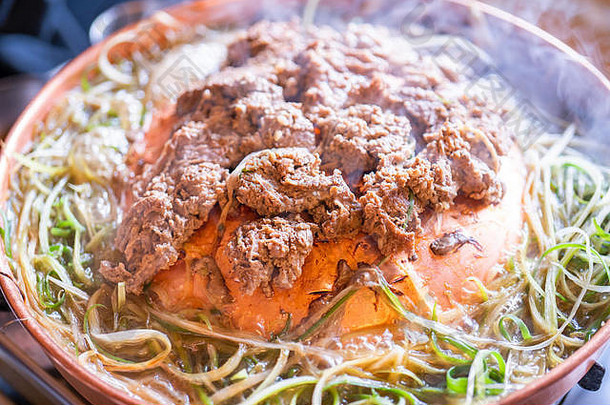 汉城韩国餐厅的牛肉烤肉bulgogi，铜锅上的生活方式新鲜韩国美食，洋葱片，特写，空间