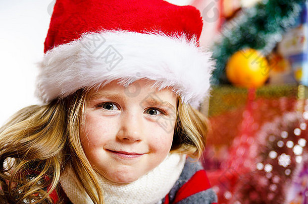 戴着红色圣诞帽的可爱小女孩的圣诞肖像画被隔离在白色的墙上
