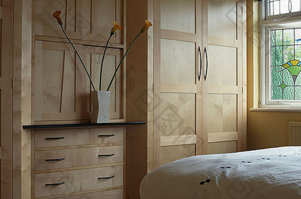 现代联排别墅卧室的浅色木制衣柜和抽屉柜