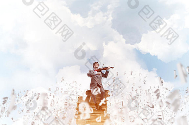 英俊的小提琴手演奏他的旋律，符号在空中飞舞