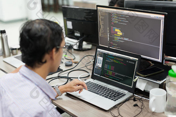亚洲外包软件开发人员屏幕坐着桌子上