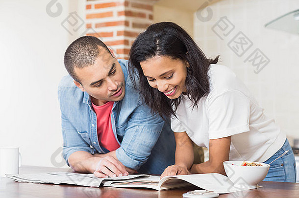 微笑夫妇阅读报纸吃谷物