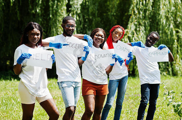 一群快乐的非洲志愿者在公园里举着白板。非洲志愿者、慈善、人与生态理念。