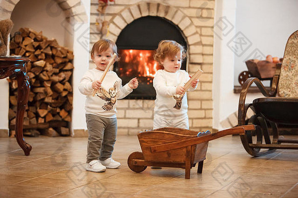 两个小女孩靠着壁炉站在家里