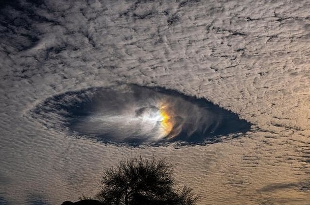 高积云中带彩虹的瀑布条纹洞看起来像是早晨天空中的宇宙飞船
