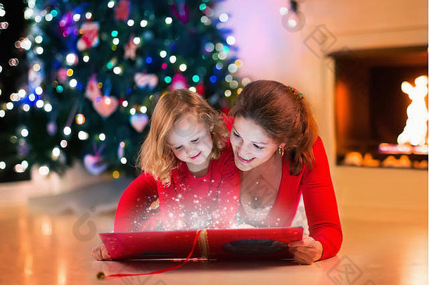 平安夜，母亲和女儿在壁炉旁看书。一家人带着孩子庆祝圣诞节。