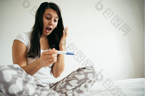 女人床上惊讶怀孕测试