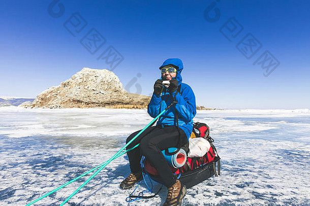 带着雪橇和登山杖的女孩在贝加尔湖的冰面上。