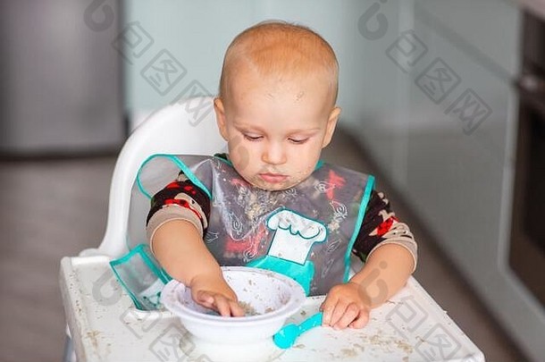 可爱的小<strong>宝宝</strong>正在吃他的第一份粥。婴儿补充食品
