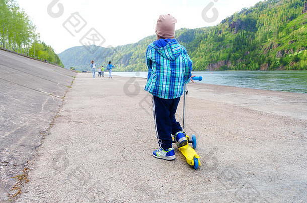一年男孩滑冰踏板车山公园