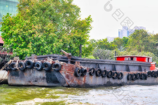 这张独特的照片展示了在曼谷湄南河上航行的传统货船