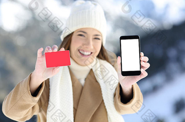 冬季雪山上一名妇女的正面照片，展示了一张卡片和手机屏幕