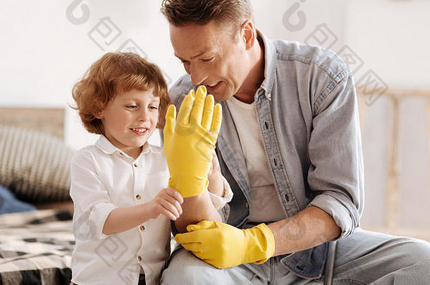 微笑的男孩看着他爸爸的手