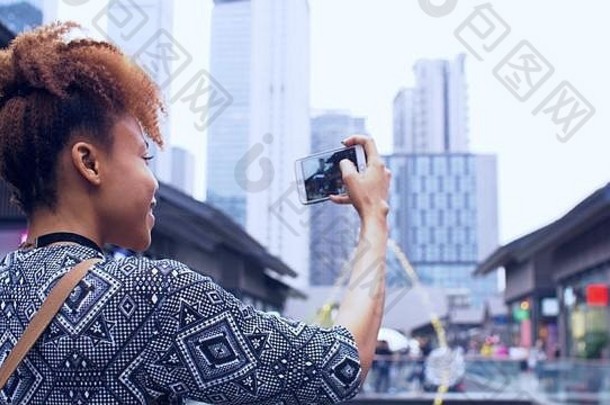 关闭快乐年轻的非洲女人移动电话采取照片街快乐的黑色的令人愉快的女孩旅行成都享受城市
