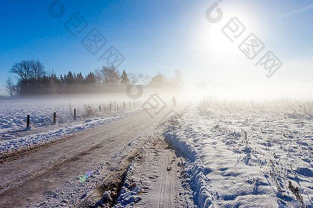 母亲和孩子在农场附近雾蒙蒙的雪路上