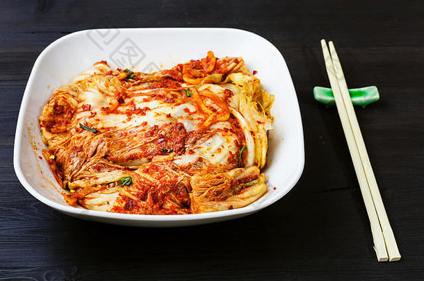 朝鲜文厨房泡菜开胃菜辣的软羊革卷心菜白色碗筷子黑暗棕色（的）木表格