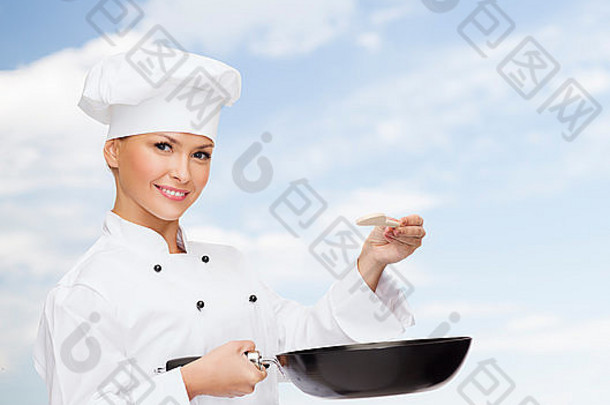 带着平底锅和汤匙微笑的女厨师