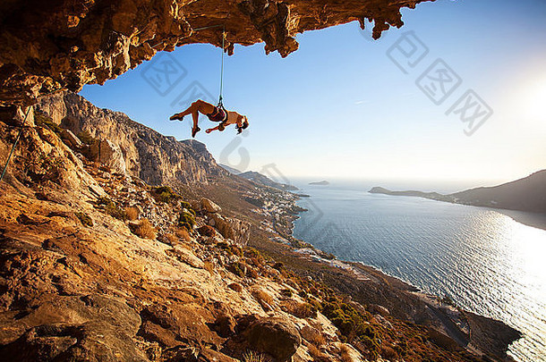 女攀岩者在攀岩过程中试图抓住悬崖上的下一只手失败后被绳子吊住