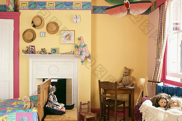 儿童黄色卧室角落里的中国纸风筝，墙纸边框和白色小壁炉