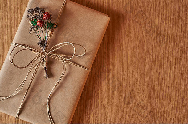 一种书状的礼物，用牛皮纸包着，用牛皮纸线绑着，里面有一小束干燥的野地植物。