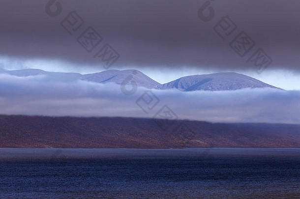 黑暗多云的晚上北欧山多雨的云湖一边山背景