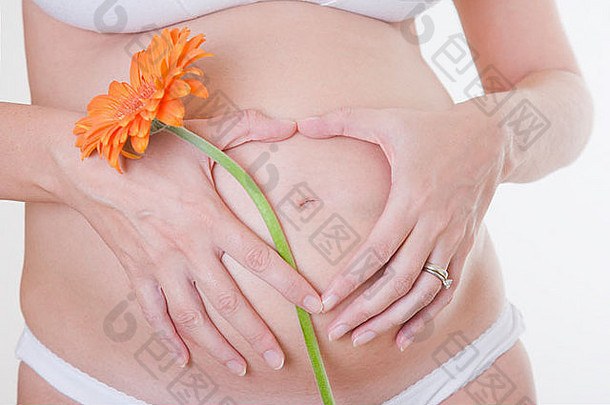 怀孕六个月的女人，戴着格伯雏菊和<strong>心</strong>形手