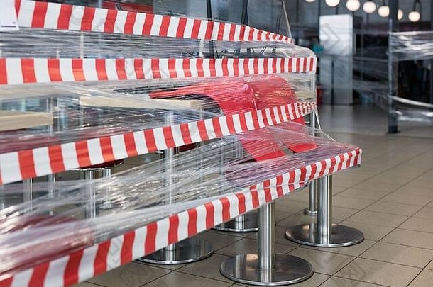 由于冠状病毒检疫，关闭的咖啡馆的桌椅被胶带卷绕