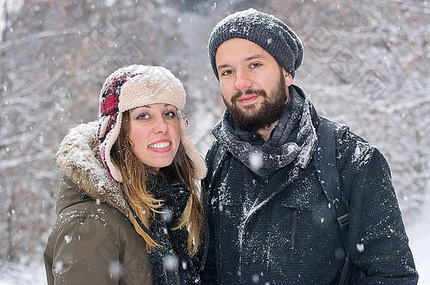 留胡子的男孩和布鲁内特女孩在雪地里摆姿势