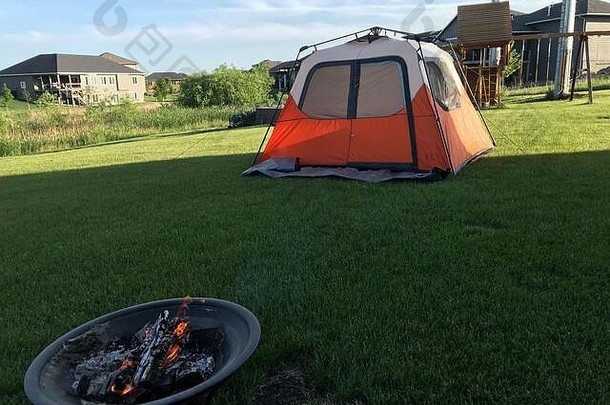 在城里的后院露营，有帐篷、操场和火坑