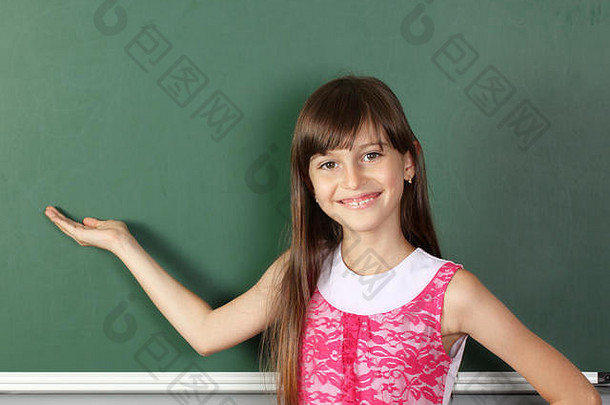微笑的孩子握着他的手靠近空空的学校黑板，空间