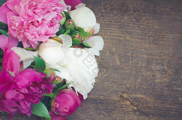 牡丹背景。木桌上有紫红色、粉色和白色的牡丹花，上面有文字。春花牡丹。母亲节快乐。母亲节的问候