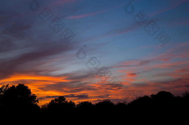 秋天傍晚的日落，在英国弗雷明翰萨福克郡上空看到稀疏的粉红色和金橙色的高海拔卷<strong>云</strong>