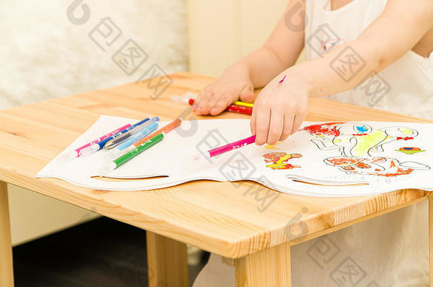 活跃的学前教育年龄孩子可爱的蹒跚学步的女孩金发女郎卷曲的头发画图片纸色彩斑斓的铅笔记号笔坐着木表格在室内首页幼儿园
