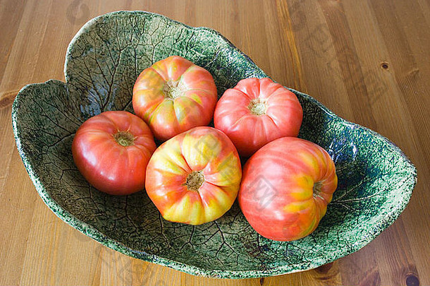 成熟的大红色有机西红柿放在绿色的番茄盘上