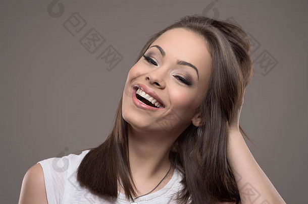 惊人的美丽的年轻的女人微笑相机手头发灰色工作室背景