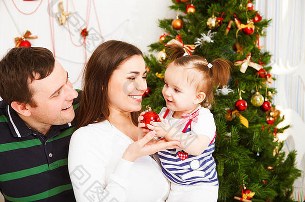圣诞树旁有一个快乐的小家庭和圣诞宝宝