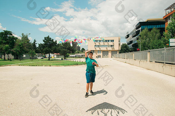 年轻的少年玩风筝阳光明媚的一天学校院子里