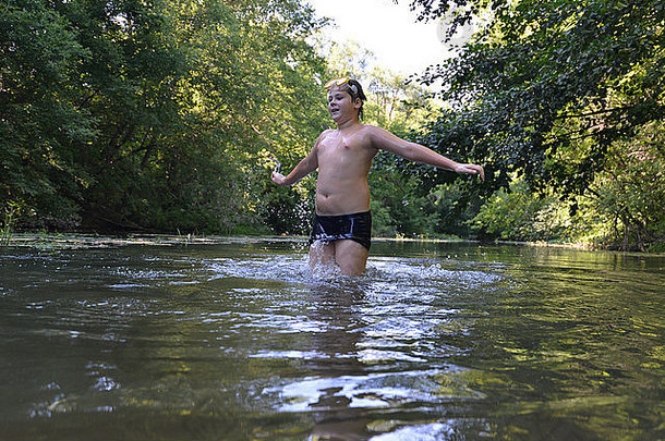 少年男孩夏天在河里游泳