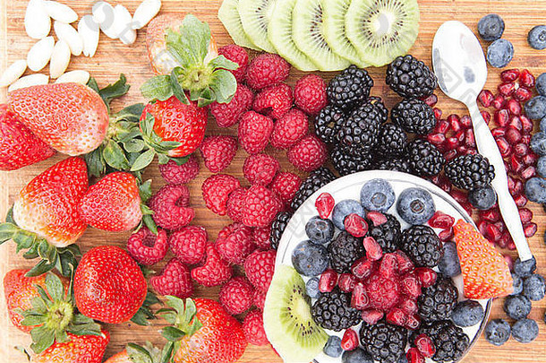准备美味健康的浆果沙拉，柜台上摆放各种新鲜水果，包括草莓、覆盆子