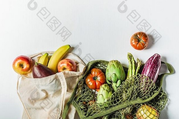 新鲜蔬菜装在一个绿色的线状袋子里，水果装在一个由天然材料制成的袋子里，浅灰色背景是一种<strong>环保产品</strong>。没有塑料。