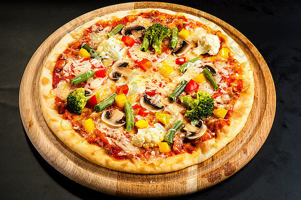 深色背景的素食比萨，配蘑菇、奶酪和甜椒