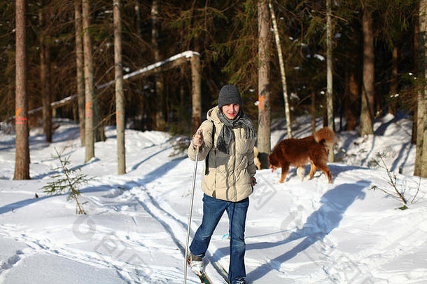 在一个阳光明媚的冬日，年轻人穿越被破坏的森林越野<strong>滑雪</strong>