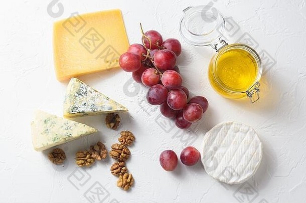 白底什锦混合奶酪、葡萄、坚果、意大利和法国奶酪和水果拼盘，配蜂蜜和葡萄酒。顶视图。