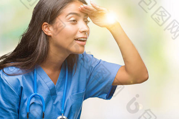 孤立背景下的年轻阿拉伯医生和外科医生非常开心，微笑着用手捂着头看着远方。<strong>搜索</strong>概念。