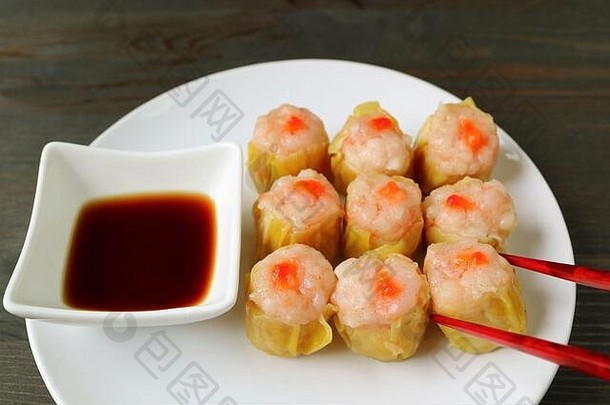 用红筷子夹起一个舒麦或虾猪肉馅的中国蒸饺